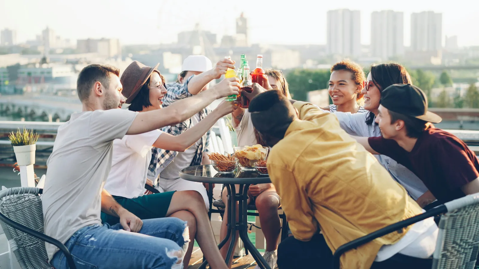 Friends toasting drinks on a rooftop party.
