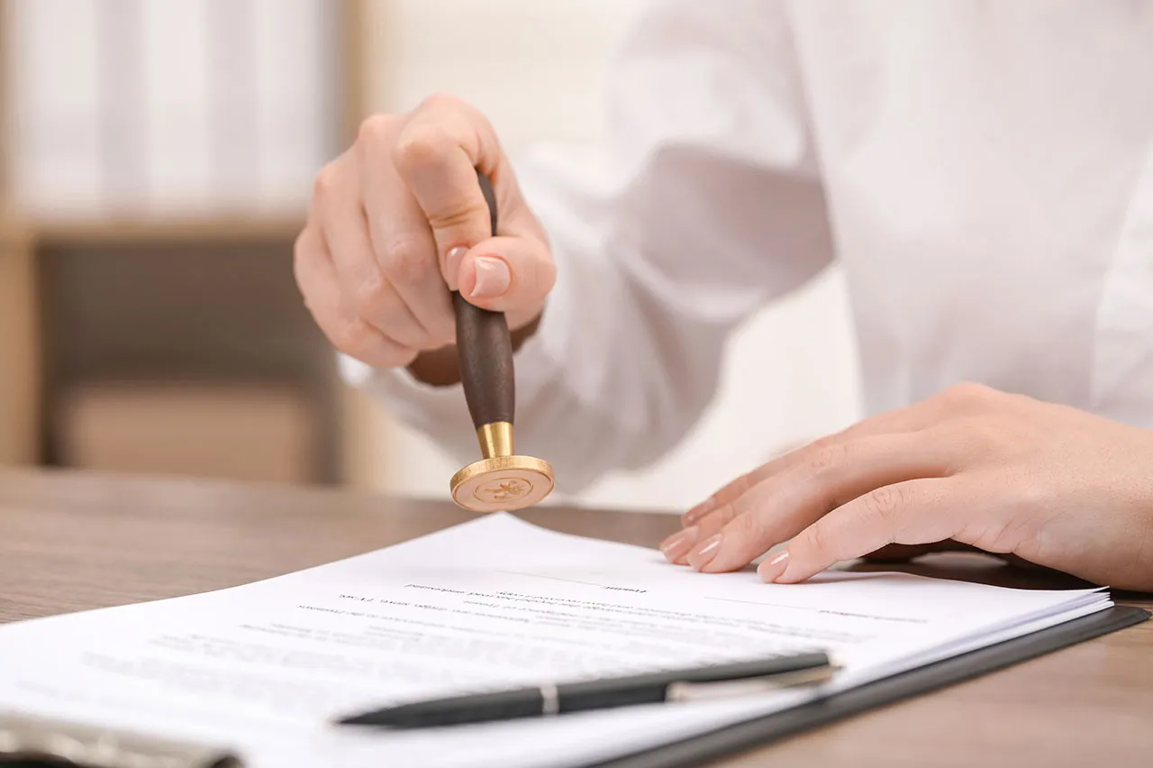 a person stamping a document, illustrating the apostille