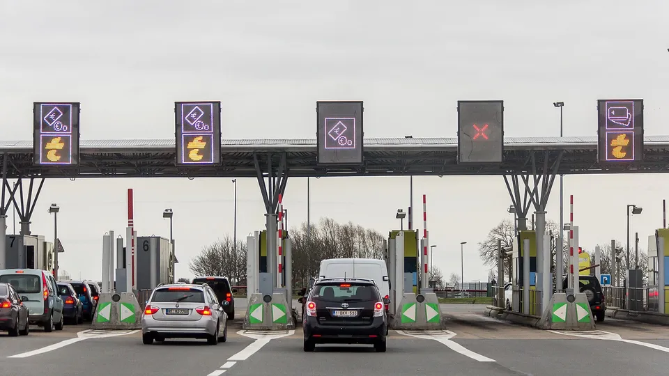 Cars queuing in the lanes of a motorway toll plaza on the A2 at Hordain.