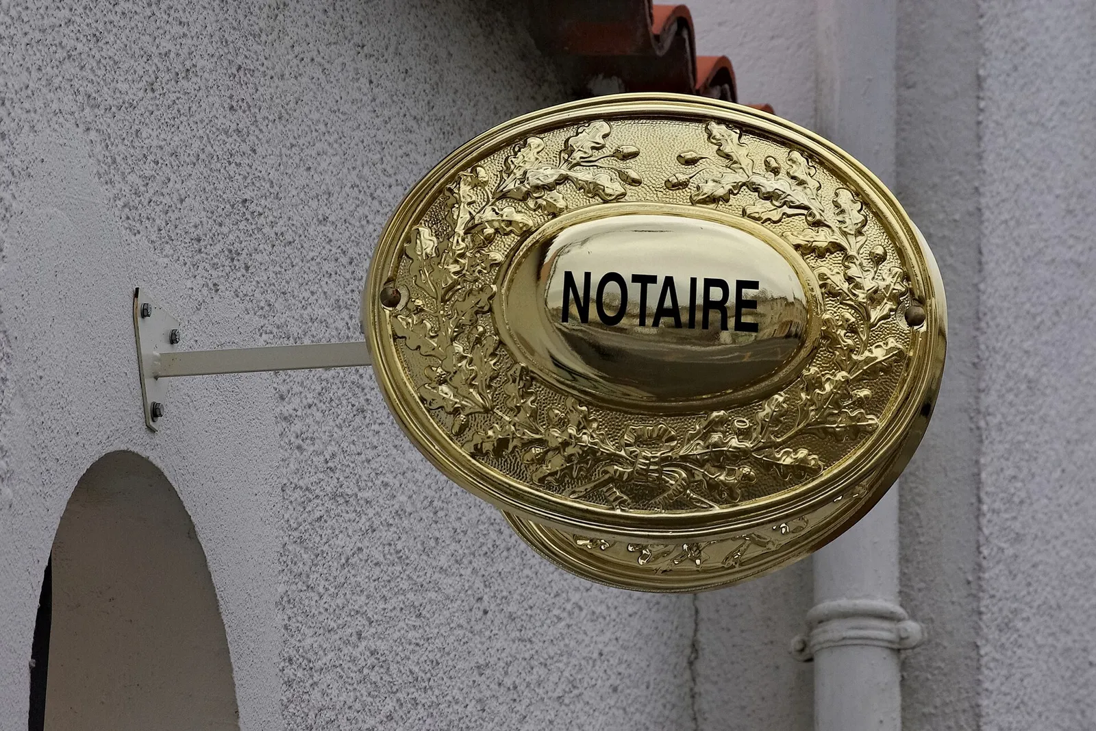 The brass sign of a notaire office in Soyaux, Charente