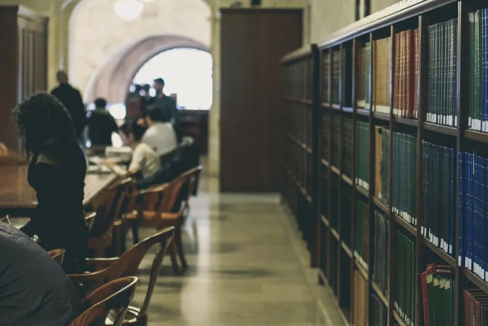 Students working at tables in a library.